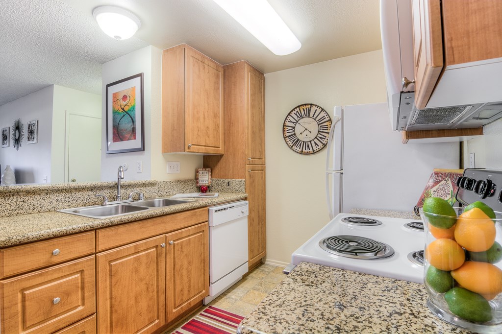 A kitchen with wooden cabinets and a white stove top oven.