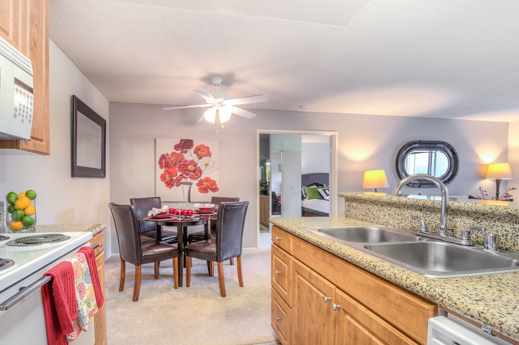 A kitchen with a table and chairs in the middle.