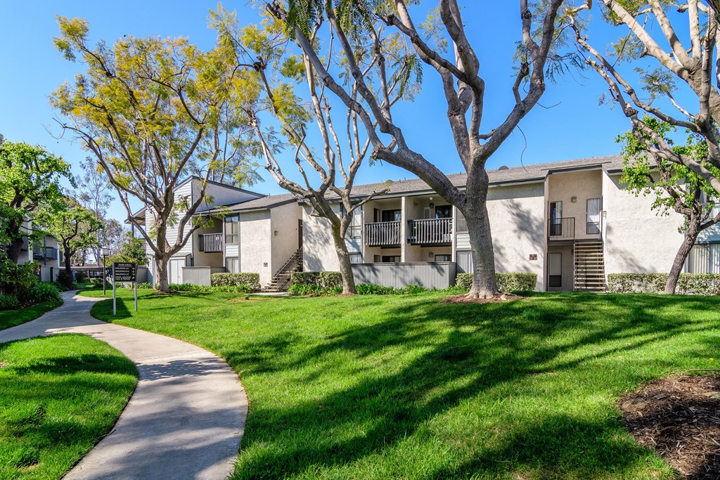 A building with a white facade and a green lawn in front.