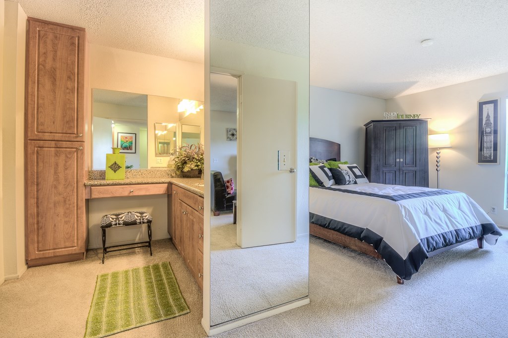 A bedroom with a bed, dresser, and mirror.
