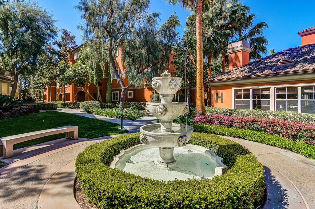 a fountain in a garden in front of a building