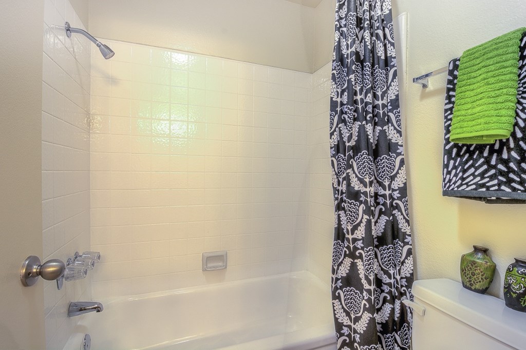 A bathroom with a white tub and a shower curtain.