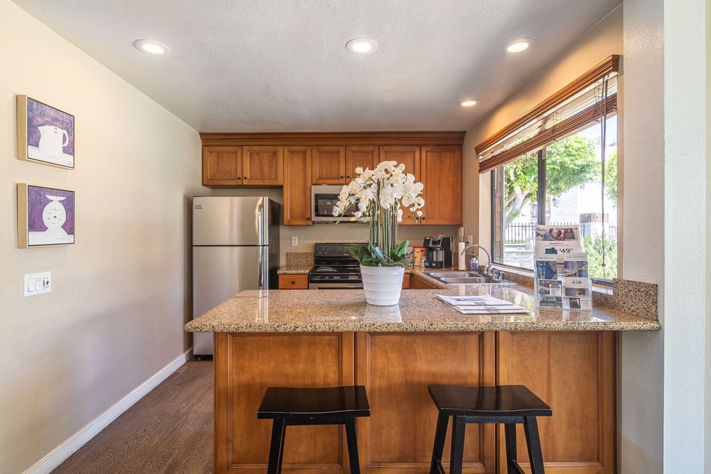 a kitchen with a granite counter top and wooden cabinets