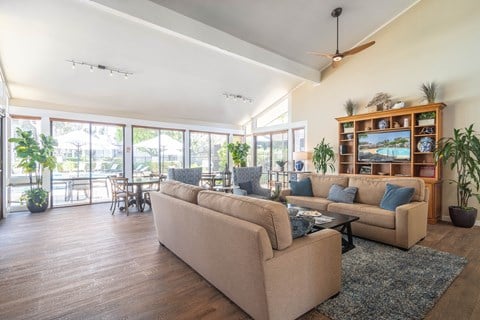 a living room with couches and a table and a balcony