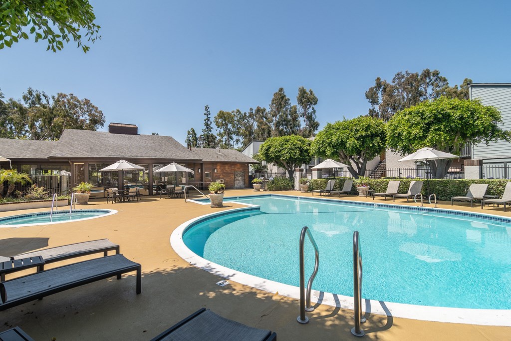 a swimming pool with chairs and umbrellas at the resort