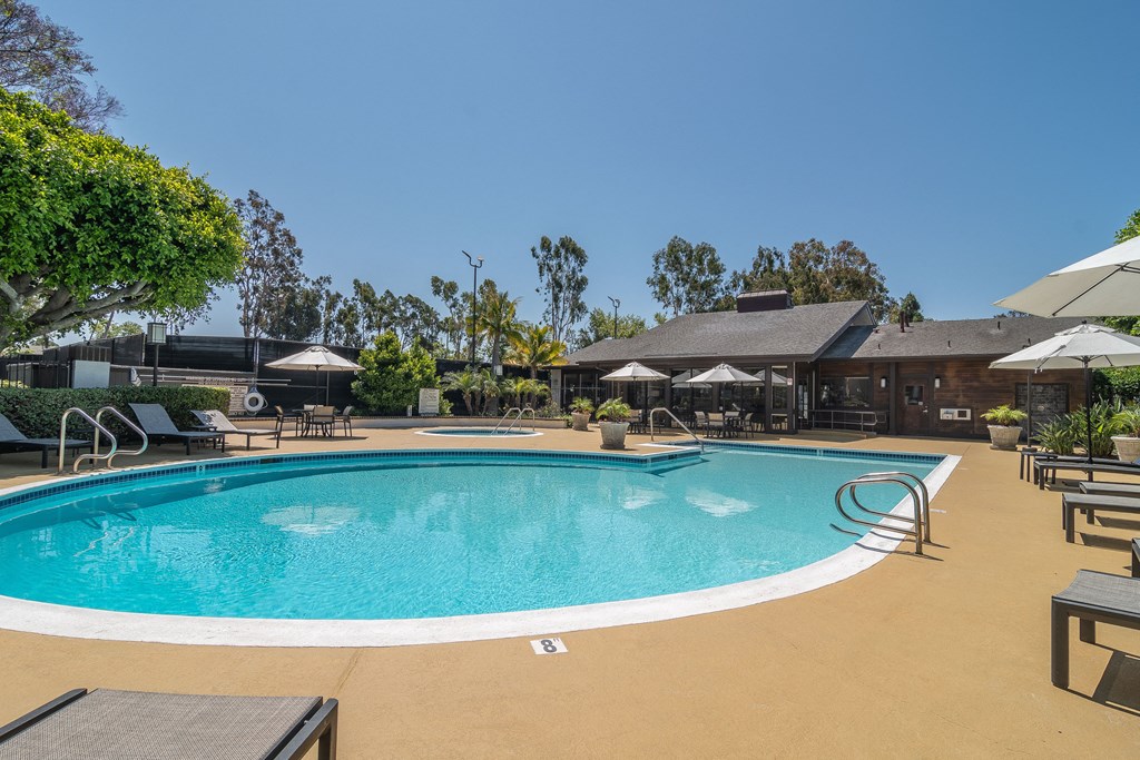 a swimming pool with chairs and umbrellas at the resort