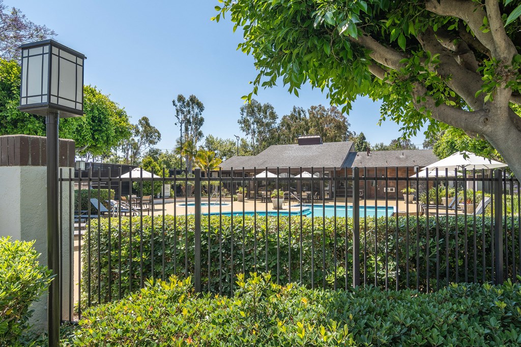 a view of the pool from behind a wrought iron fence