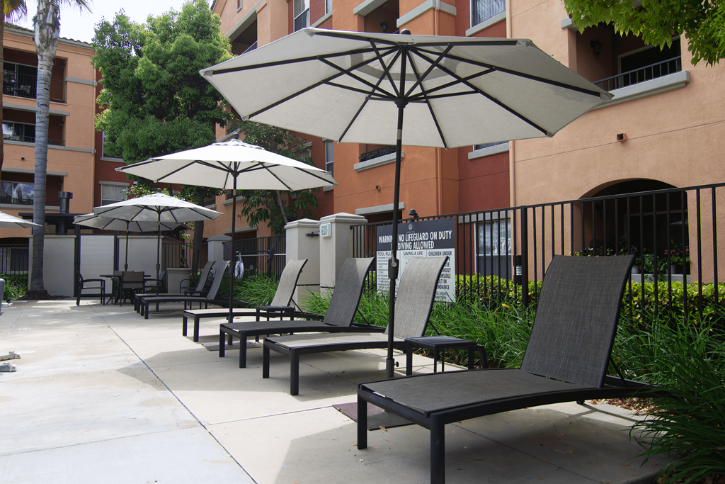 A patio with chairs and umbrellas.