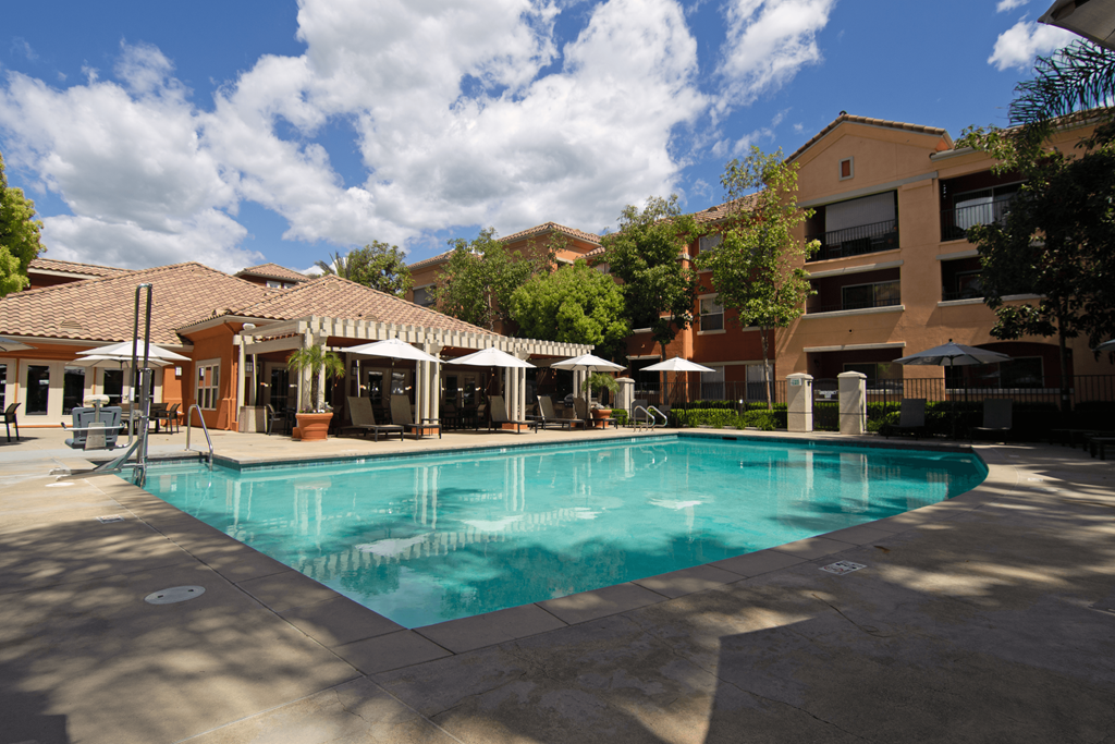 A large swimming pool surrounded by buildings and trees.