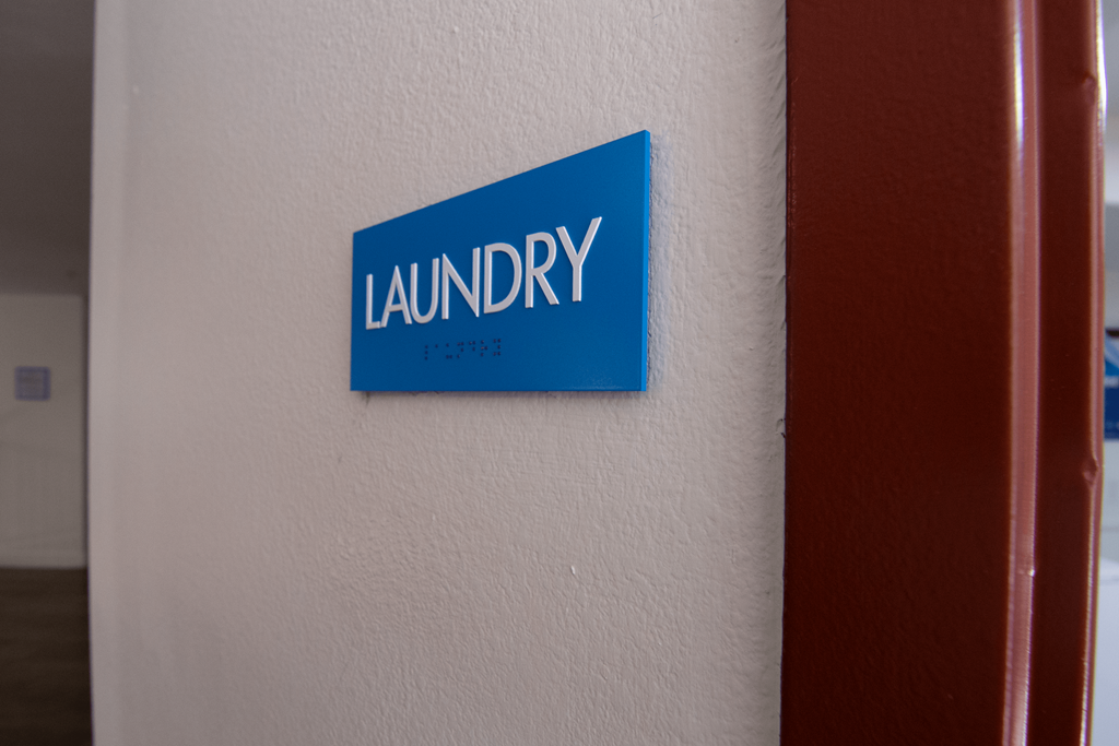 A blue sign on a wall that says Laundry.