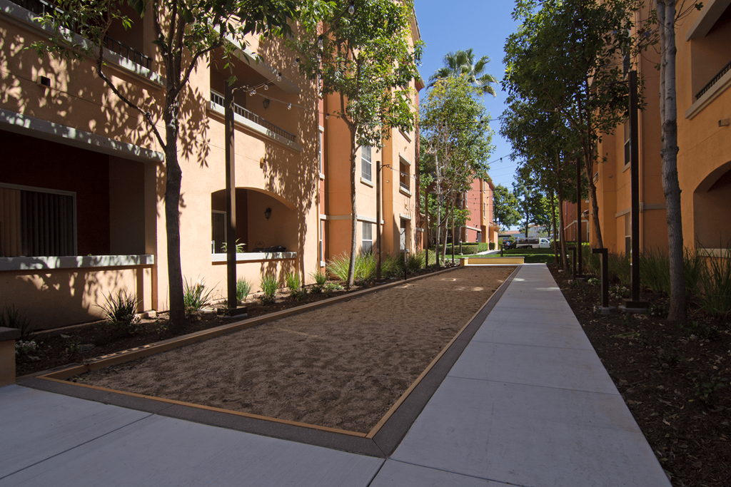 A long concrete walkway leads between two rows of buildings.