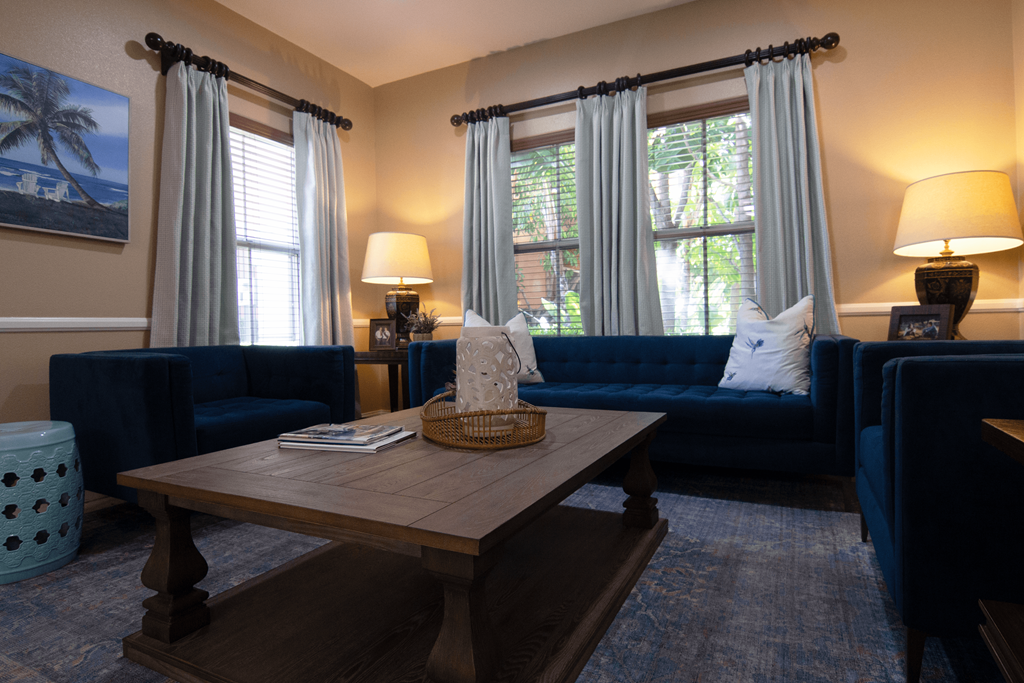 A living room with blue couches and a wooden coffee table.