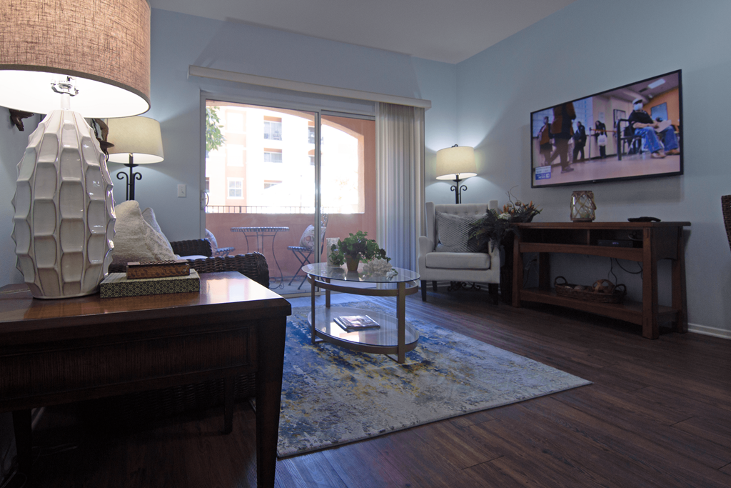 A living room with a sofa, a coffee table, a lamp, and a television.
