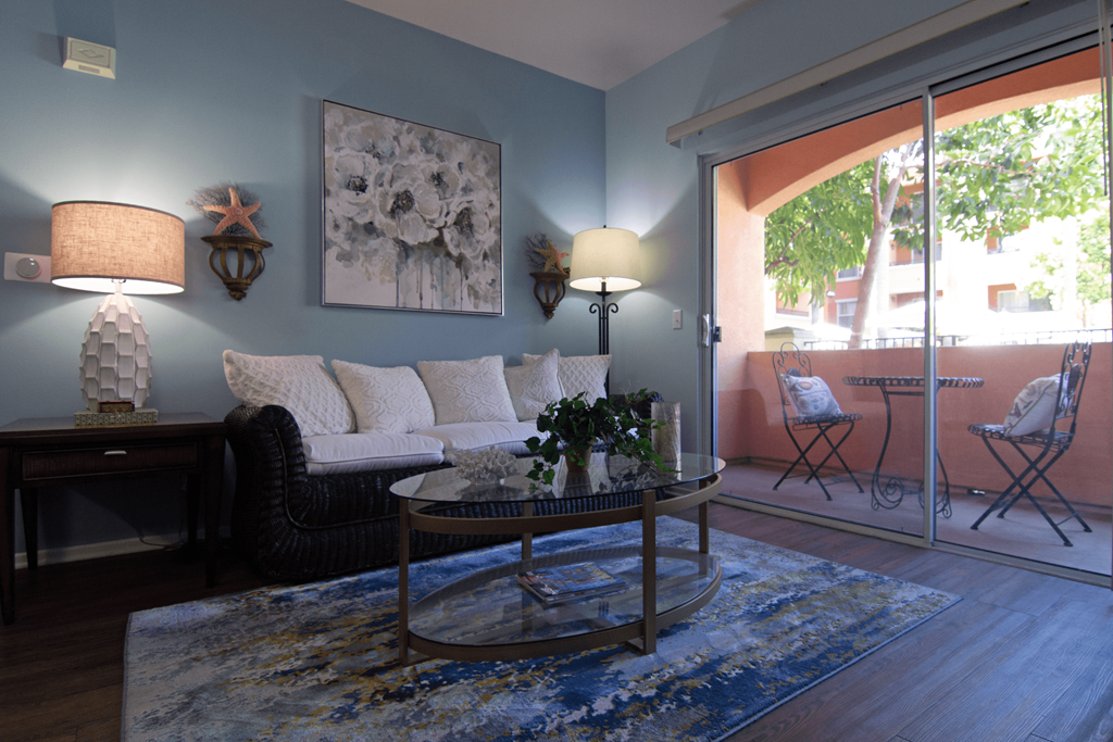 A living room with a sofa, two chairs, a table, and a painting on the wall.