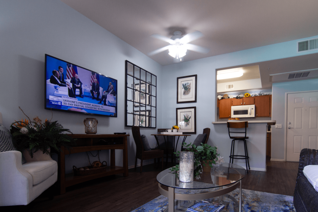 A living room with a television on the wall and a couch.