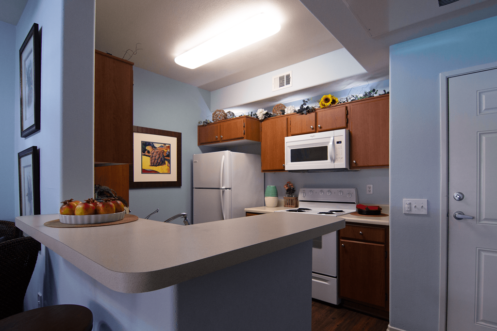 A kitchen with a counter and a fridge.