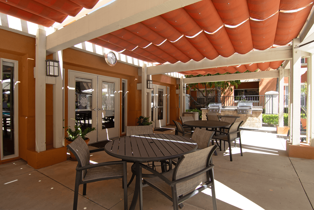A patio with a table and chairs under a roof.