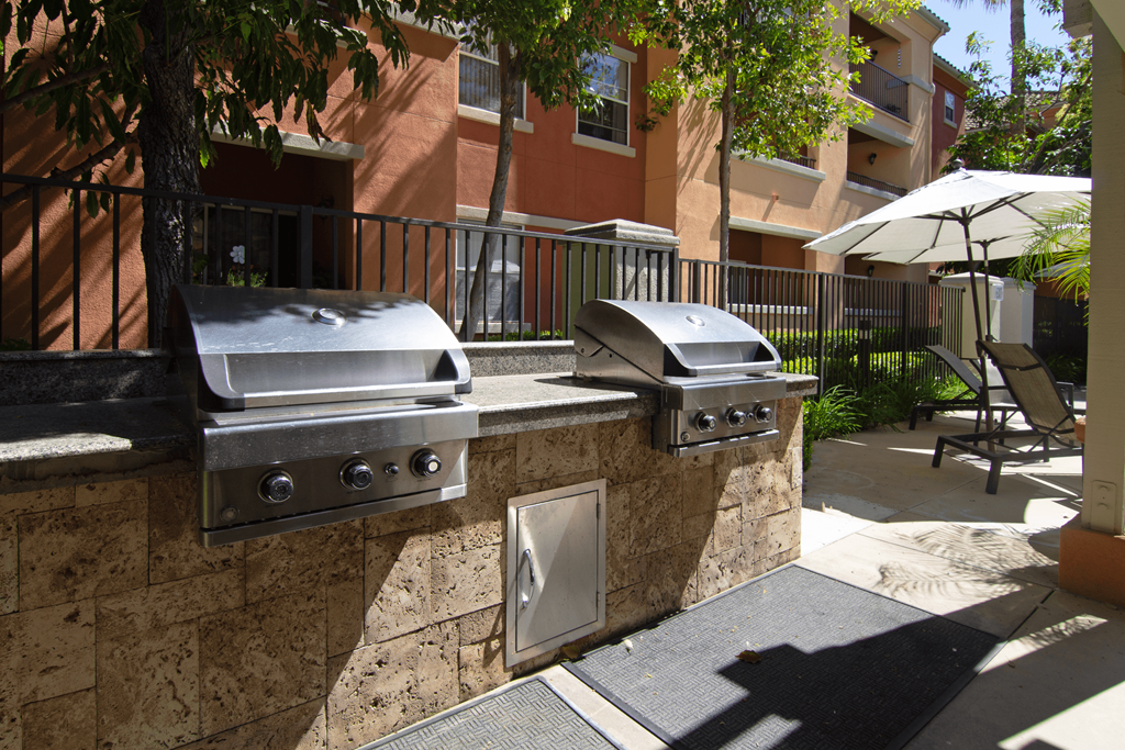 Two built-in grills on a stone wall outside a building.