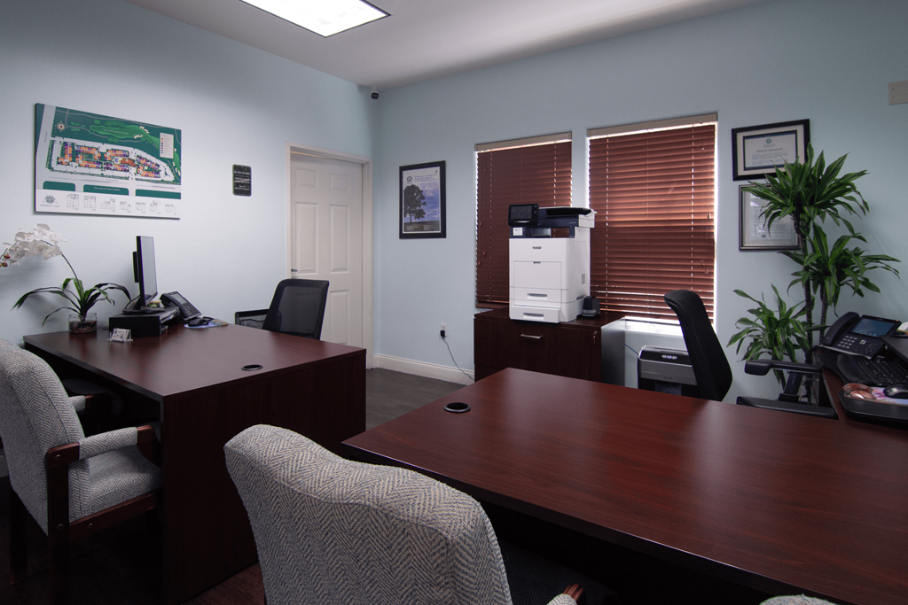 A room with a desk and chairs.