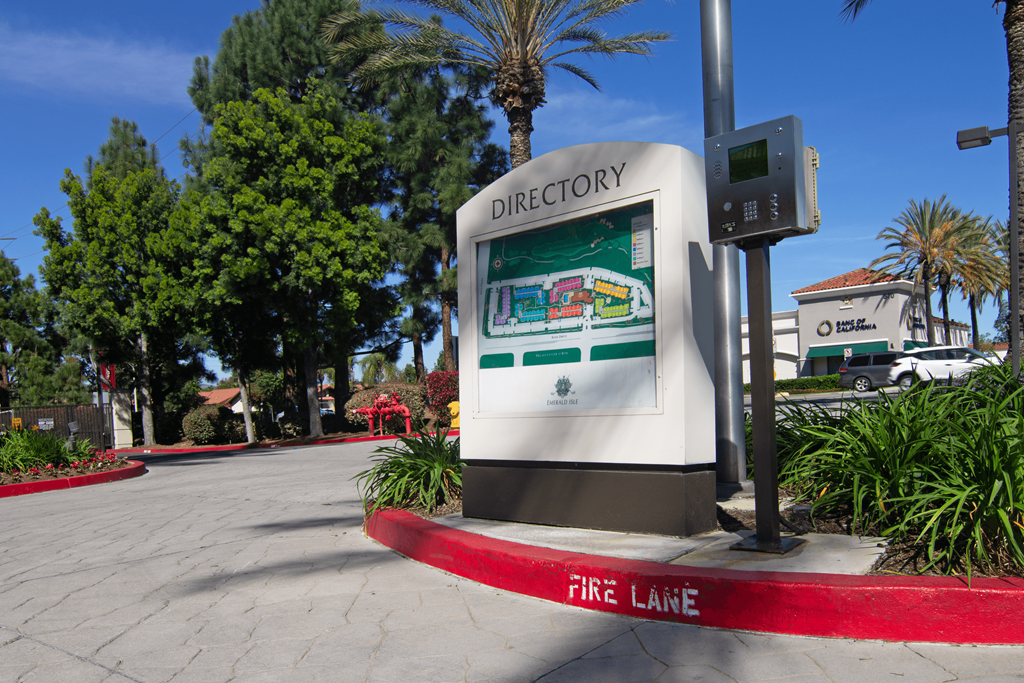A directory sign is on a pole in front of a fire lane.