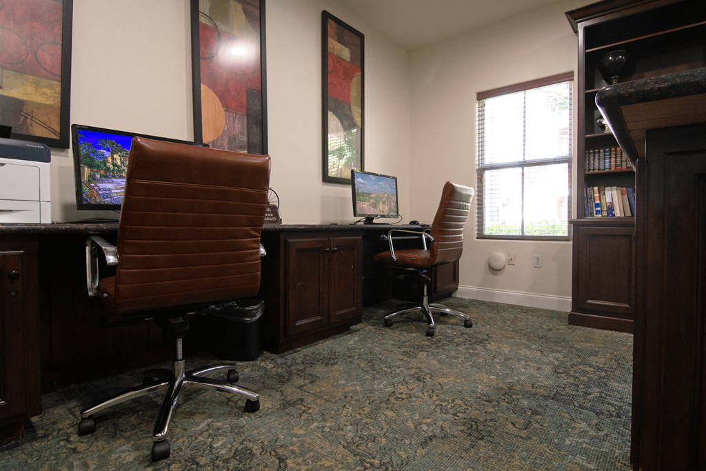 A room with two chairs and two computers.