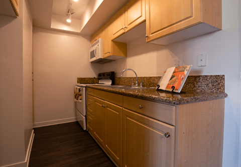 A kitchen with wooden cabinets and a granite countertop.