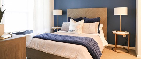 a bedroom with a bed and a blue accent wall