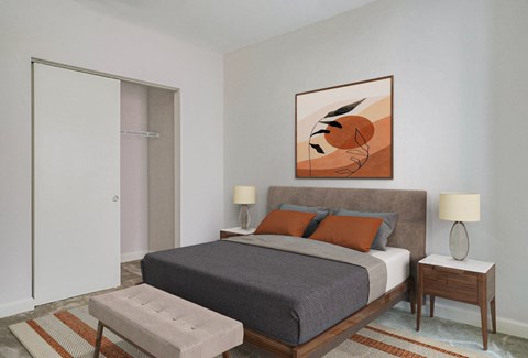 A bedroom with a bed, nightstands, and a painting on the wall.at 405 W Redwood Apartments, Maryland, 21201