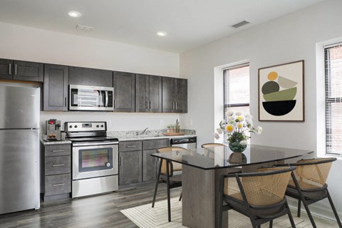 A modern kitchen with a stainless steel refrigerator and a glass island.