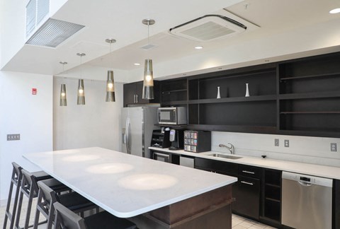 a kitchen with a white counter top and black cabinets