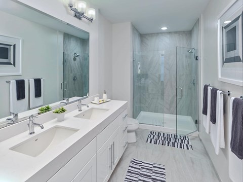 A bathroom with a white sink and a glass shower stall.