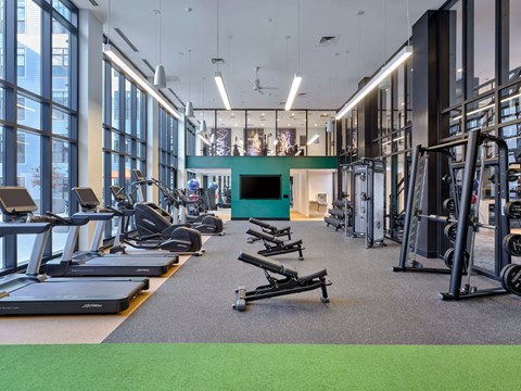 A gym with treadmills, elliptical machines, and other exercise equipment. Fitness Center.