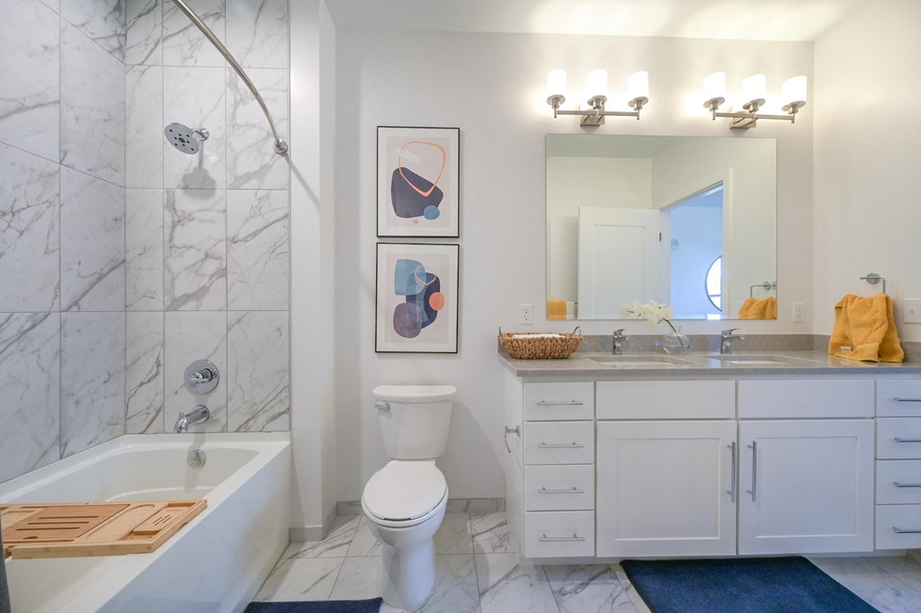 a white bathroom with a shower toilet and sink at Ingram Manor, Pikesville, MD
