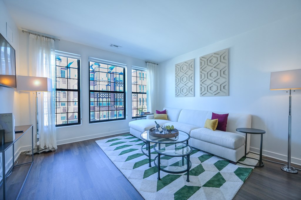 a living room with a white couch and a glass coffee table at Ingram Manor, Pikesville, MD