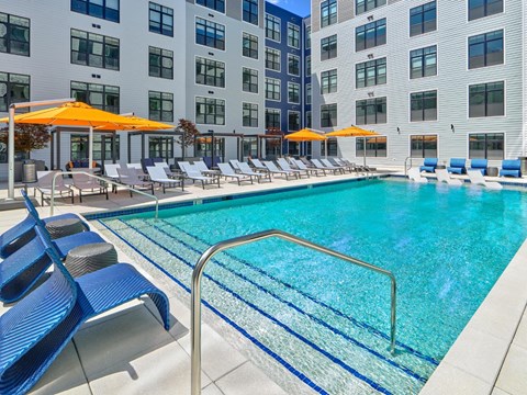 A swimming pool with outdoor seating at The Apartments at Metro Centre