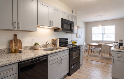 A kitchen with a black oven and a black microwave above the stove.