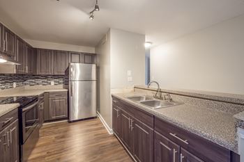 an empty kitchen with granite counter tops and stainless steel appliances