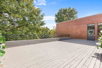 a wooden deck in front of a brick building at Crogman School Lofts, Atlanta, GA 30315