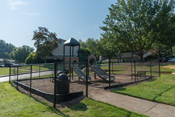 a playground with two slides and a swing set in a park at Bradford Gwinnett Townhomes, Norcross Georgia