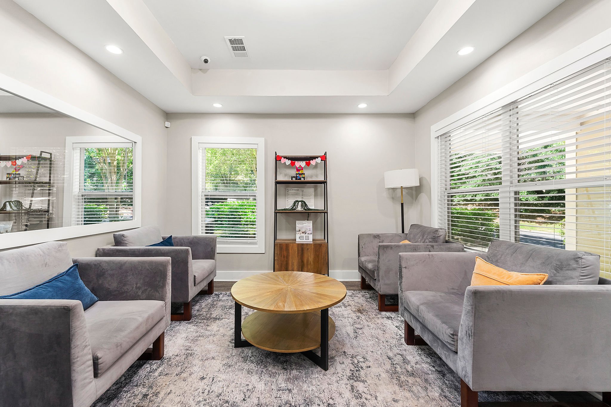 A living room with grey couches and a wooden coffee table.