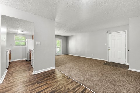 A spacious room with wooden floors and white walls.