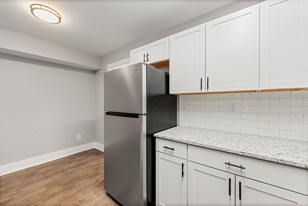 Renovated and open kitchen with white cabinets and stainless steel appliances at Crogman School Lofts, Atlanta, 30315