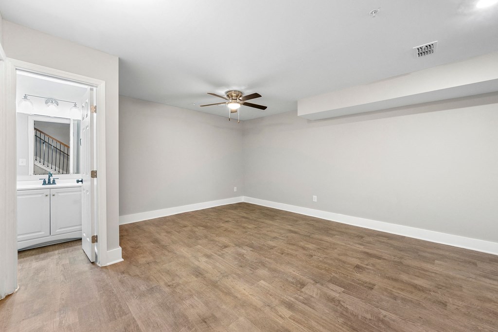 an empty living room with white walls and a ceiling fan