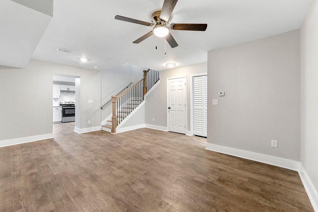 Living room with a staircase and a ceiling fan at Crogman School Lofts, Atlanta, 30315