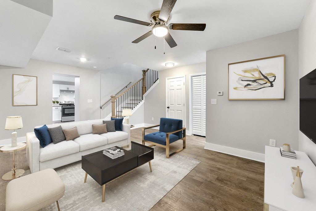 Living room with a staircase and a ceiling fan at Crogman School Lofts, Atlanta, 30315