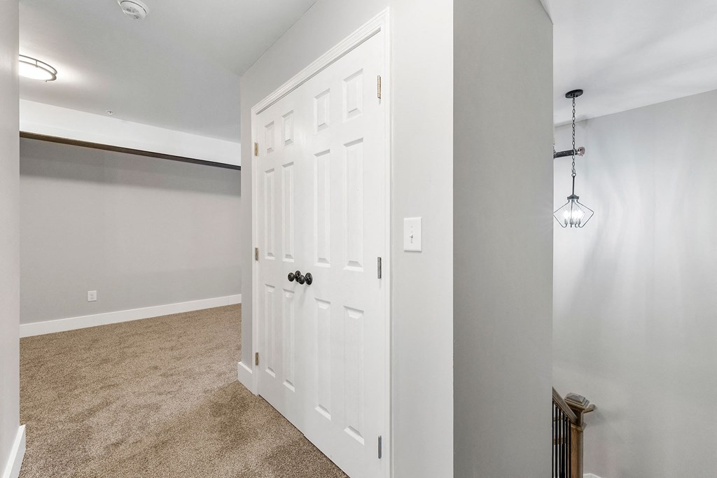an empty bedroom with a closet and a white door