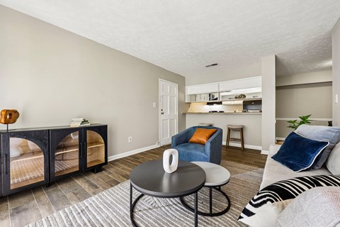 A living room with a black coffee table and a striped rug.