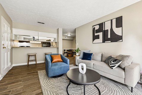 A living room with a grey couch, a blue chair, and a coffee table.