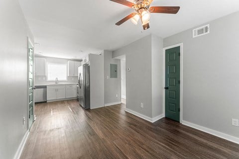 a living room with a ceiling fan and a kitchen in the background  at 1760 Memorial, Atlanta, 30317