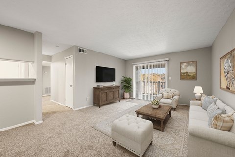 A living room with a white couch, a coffee table, and a flat screen TV.